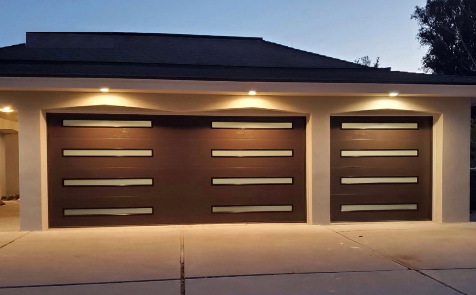 Modern double garage doors with evening lights on