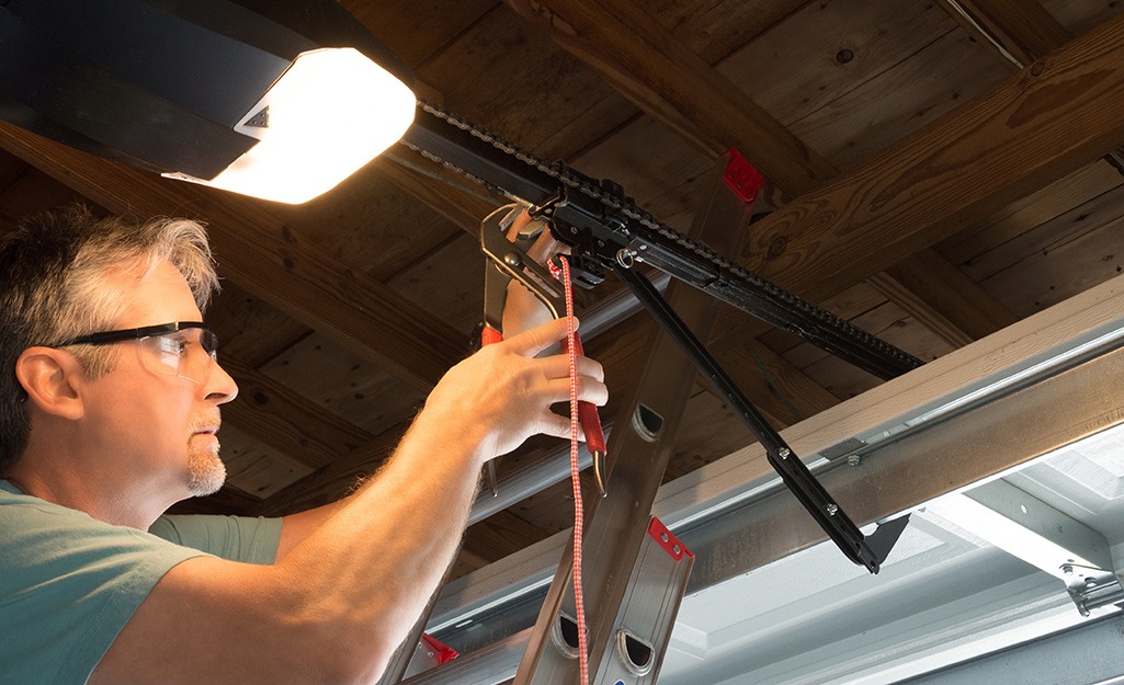 Man repairing a garage door opener in a well-lit garage