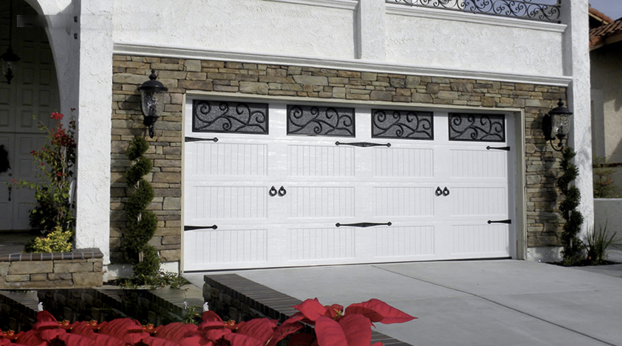 White garage door with decorative windows and stone accents
